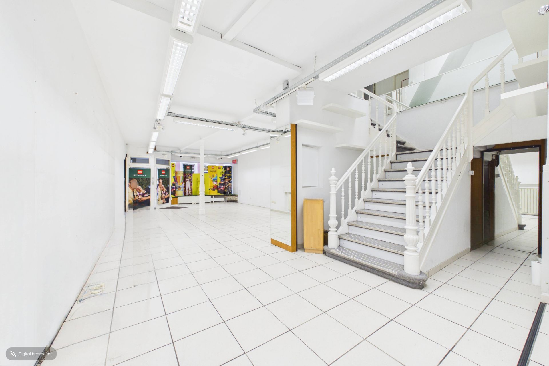 Heller Raum mit weißen Fliesen, weißen Wänden und einer weißen Treppe mit Geländer.