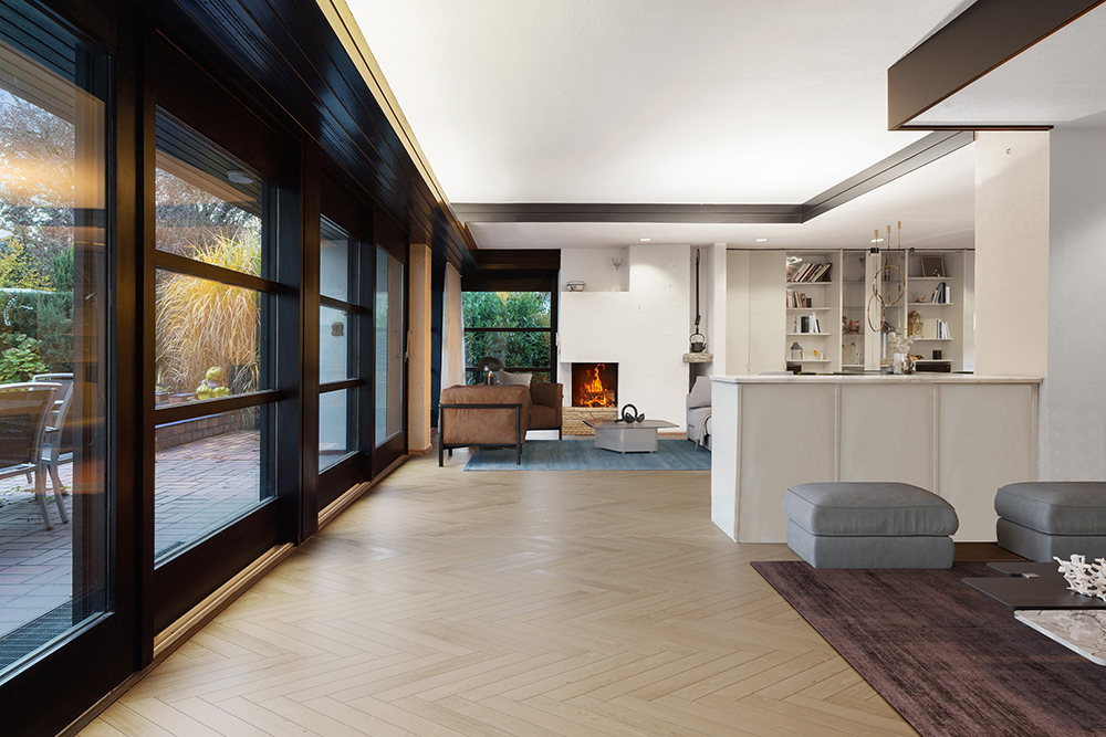 Modernes Wohnzimmer mit großen Fenstern, Kamin, Bücherregalen und Sitzbereich.