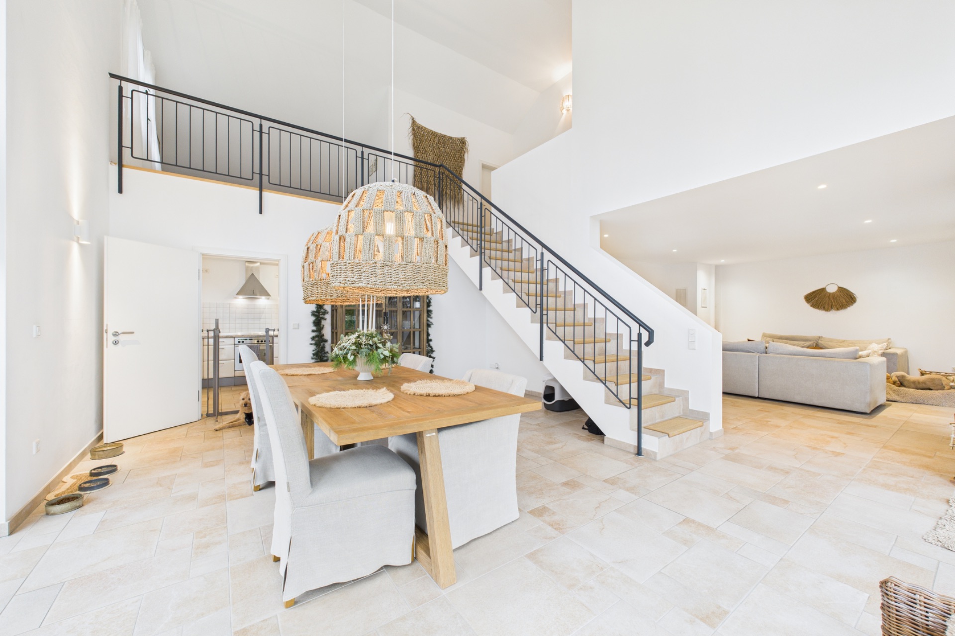 Helles Wohn- und Esszimmer mit Esstisch, Stühlen und Treppe ins Obergeschoss.
