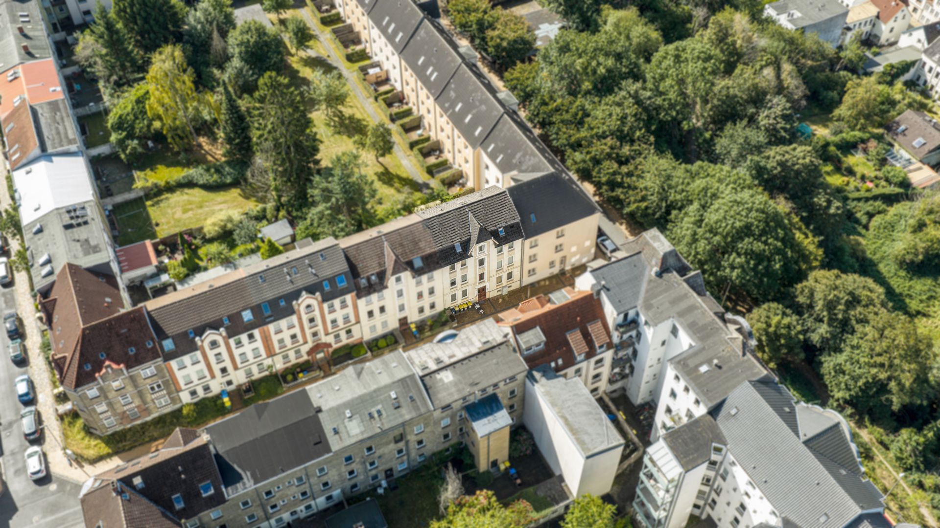 Luftaufnahme von mehreren Wohngebäuden mit Innenhöfen und viel Grün dazwischen.