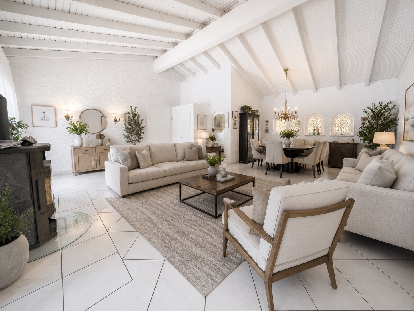 Helles Wohnzimmer mit weißen Sofas, Couchtisch, Teppich und Esstisch im Hintergrund.