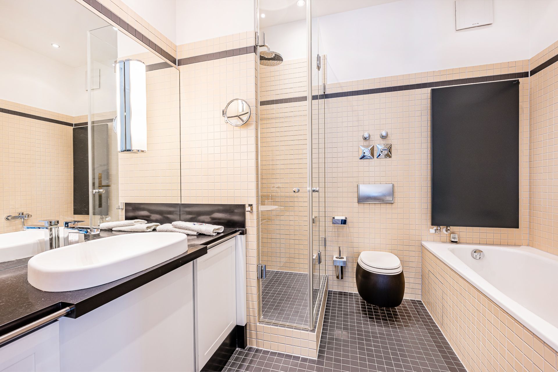 Modernes Badezimmer mit Dusche, Badewanne, Toilette und Waschbecken mit Spiegel.