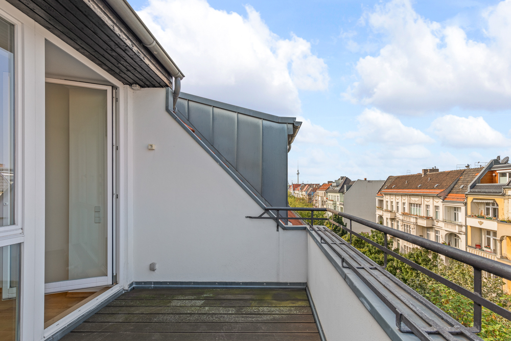 Kleiner Balkon mit Blick auf benachbarte Häuser, Zugang durch Glastür.