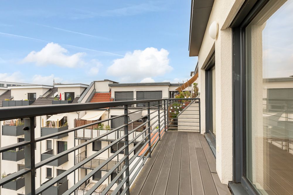 Moderner Balkon mit Metallgeländer, Blick auf Nachbargebäude.
