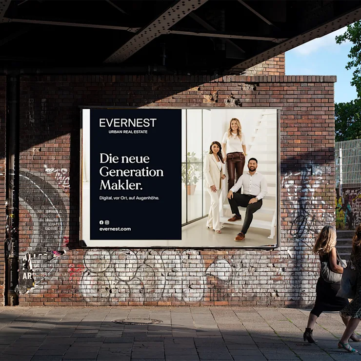Werbeplakat an einer Backsteinmauer zeigt drei Menschen vor einer Treppe und einen Textblock.