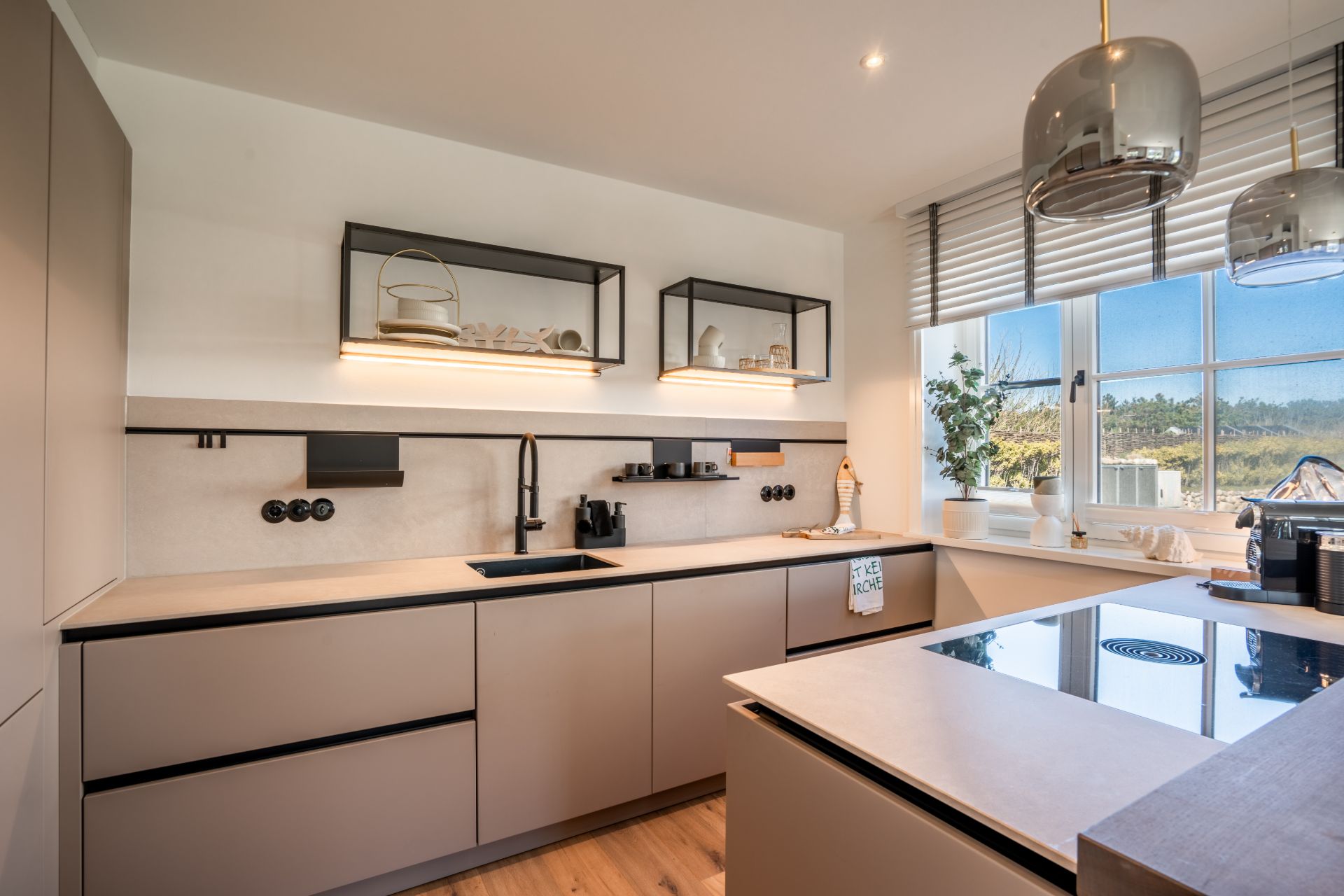 Moderne Küche mit hellem Design, großen Fenstern und Kochinsel.