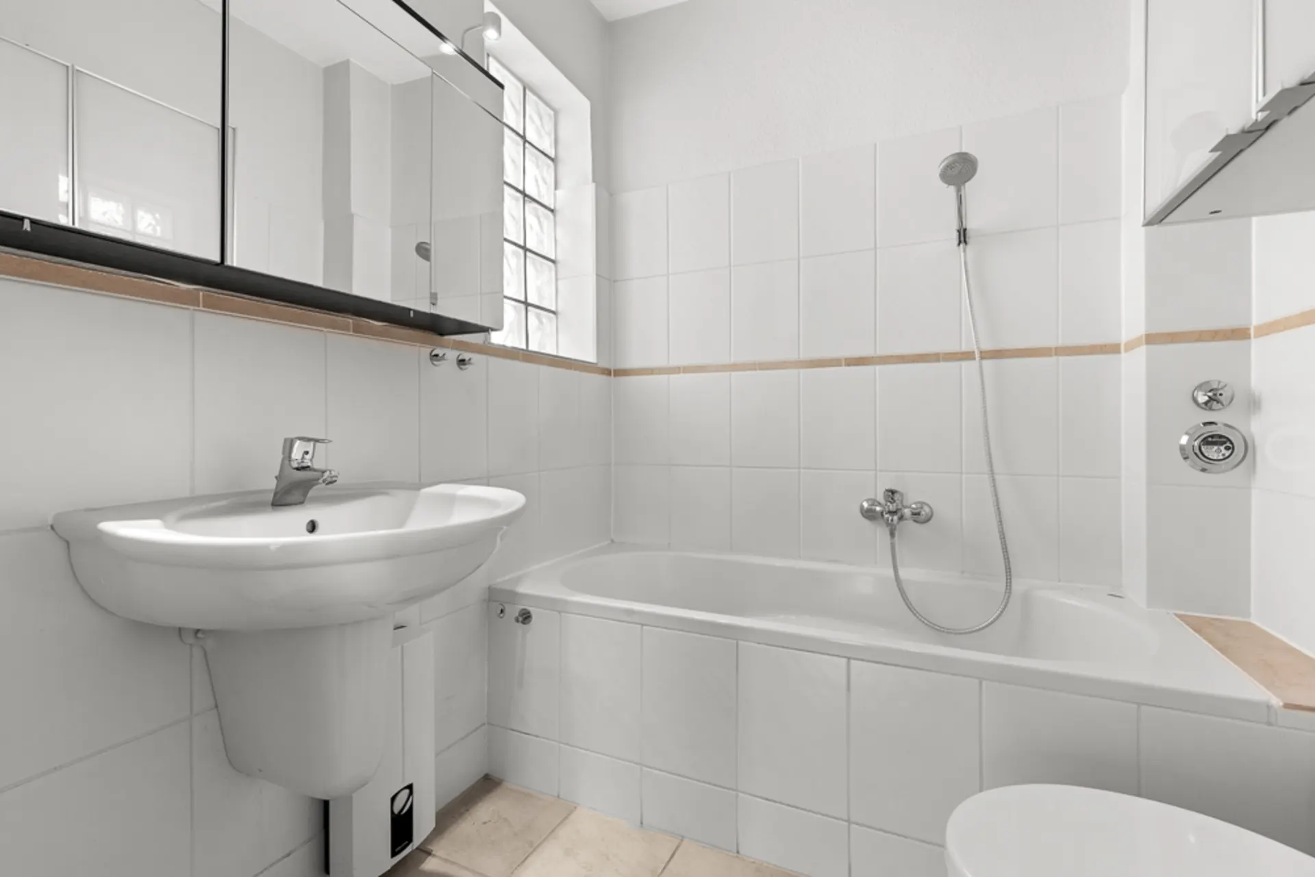 Modernes weißes Badezimmer mit Waschbecken, Badewanne und Spiegel.