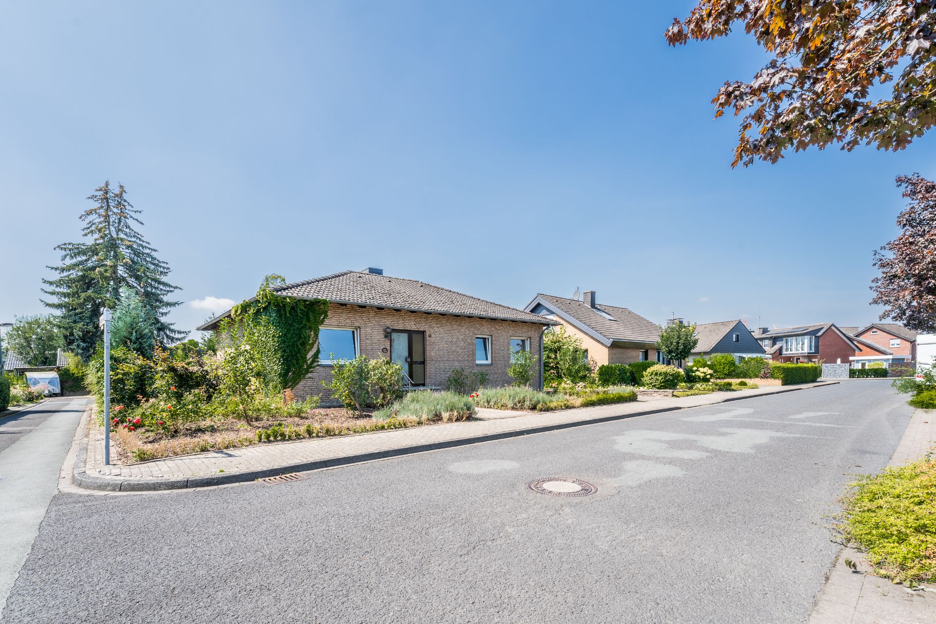 Einfamilienhaus aus Backstein mit Garten an einer ruhigen Wohnstraße.