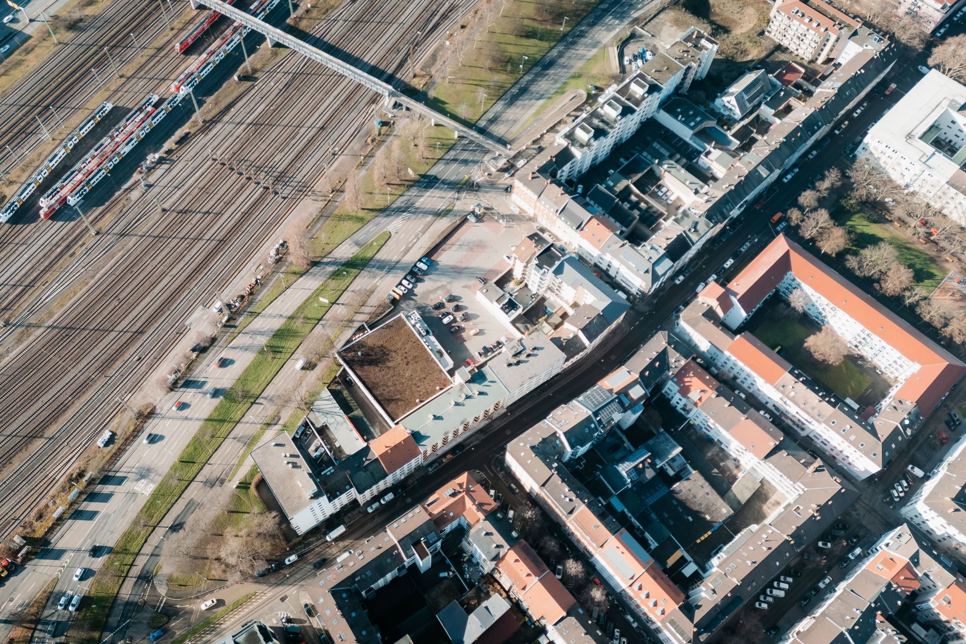 Luftbild von Wohngebäuden und Bahngleisen in einem Stadtgebiet.
