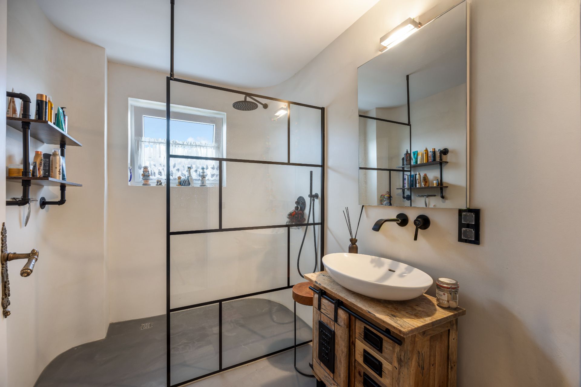 Modernes Bad mit großer begehbarer Dusche, Waschbecken auf Holzschrank und Regal mit Pflegeprodukten.