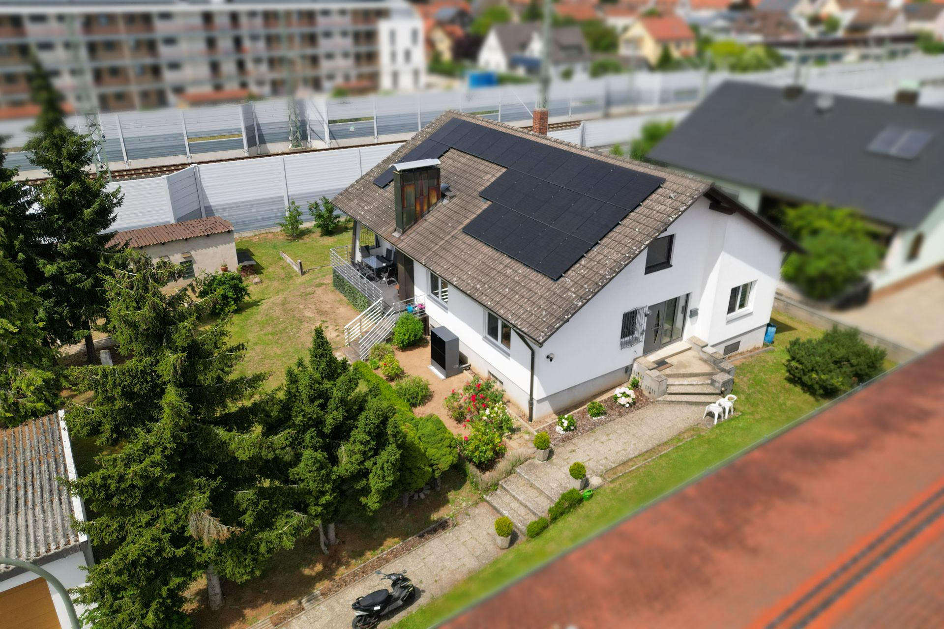 Einfamilienhaus mit Solarpanelen und Garten, von oben fotografiert.