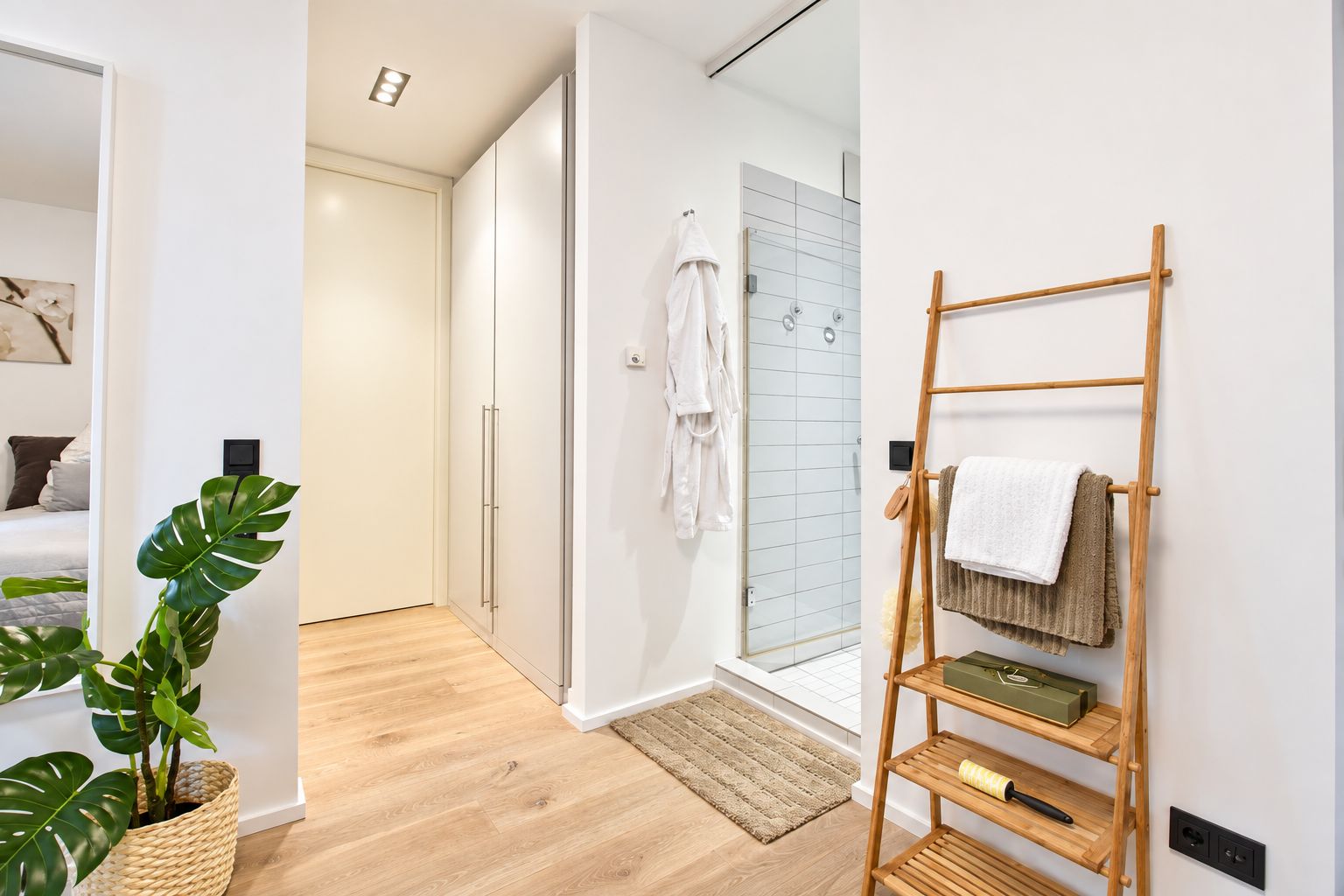 Modernes Badezimmer mit Holzleiter, Dusche, Teppich und Pflanzen im Vordergrund.