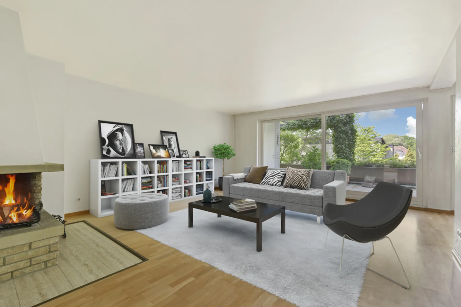 Modernes Wohnzimmer mit Kamin, großem Fenster, Sofa und Regal voller Bücher.