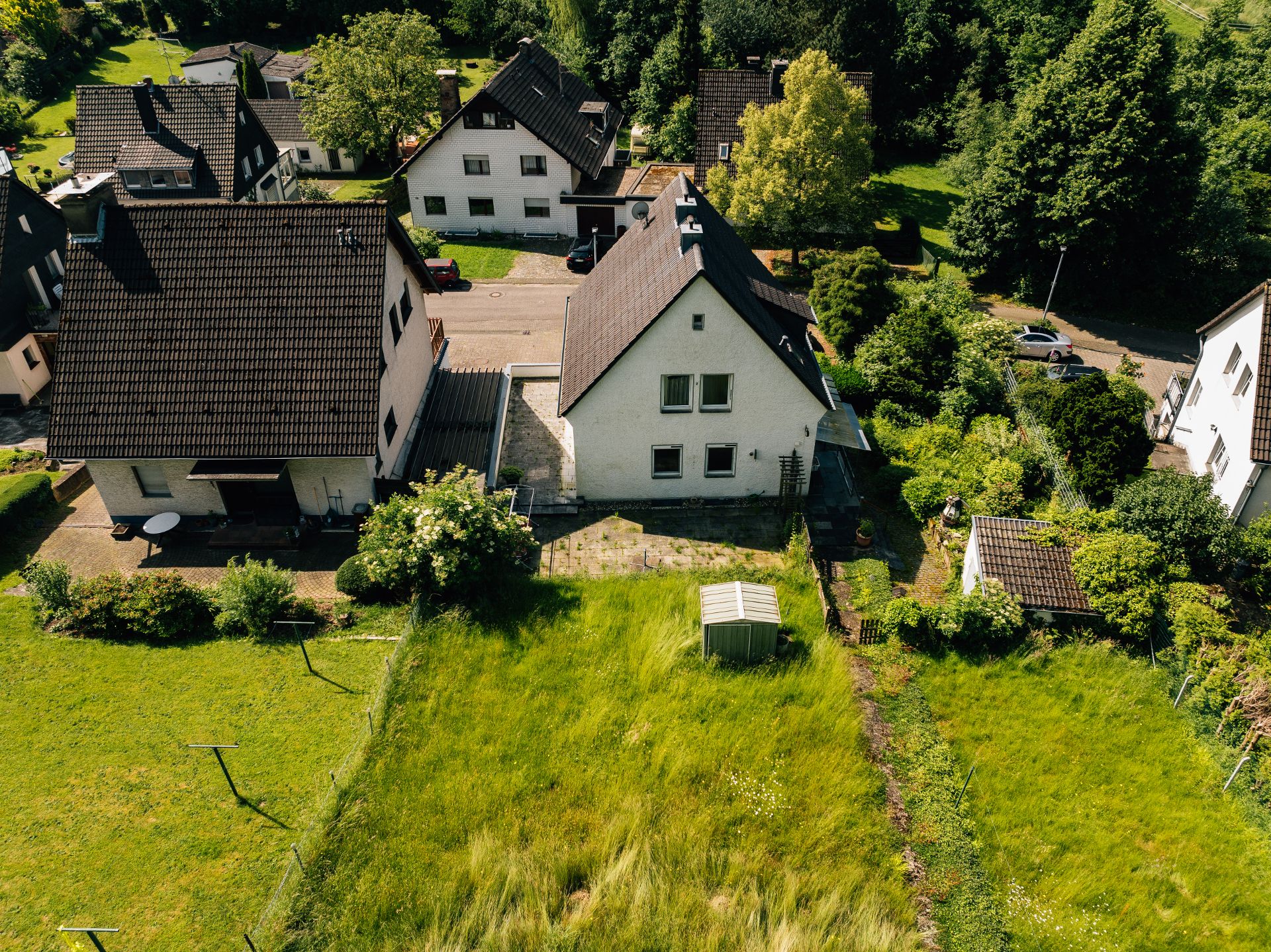 Luftaufnahme eines Wohnhauses mit Garten, Rasenfläche und kleinem Geräteschuppen.