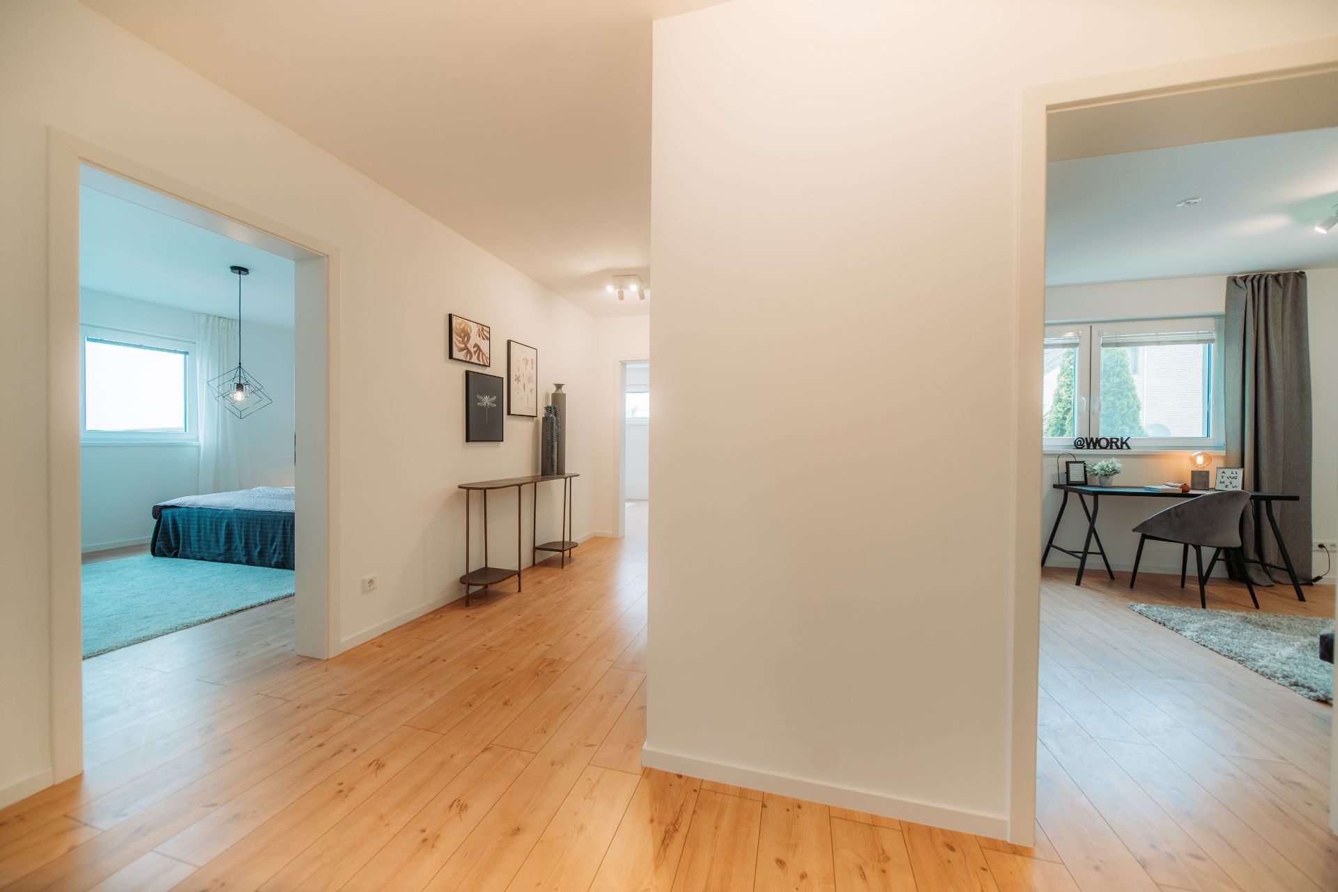 Flur mit Blick in ein Schlafzimmer links und ein Arbeitszimmer rechts, Holzboden, helle Wände.