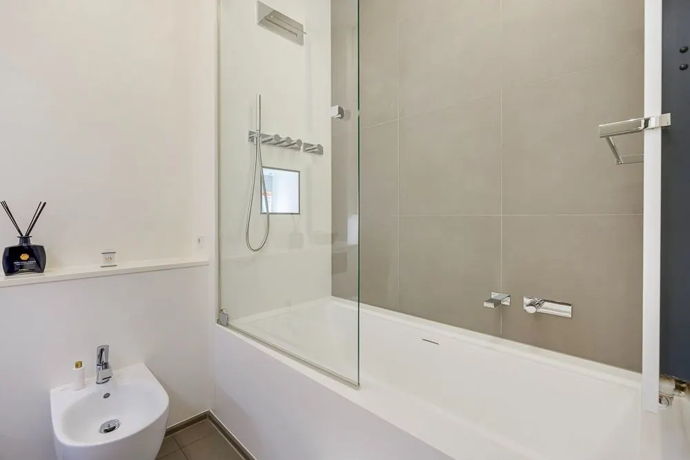 Modernes Badezimmer mit Badewanne, Glasduschabtrennung und Bidet.