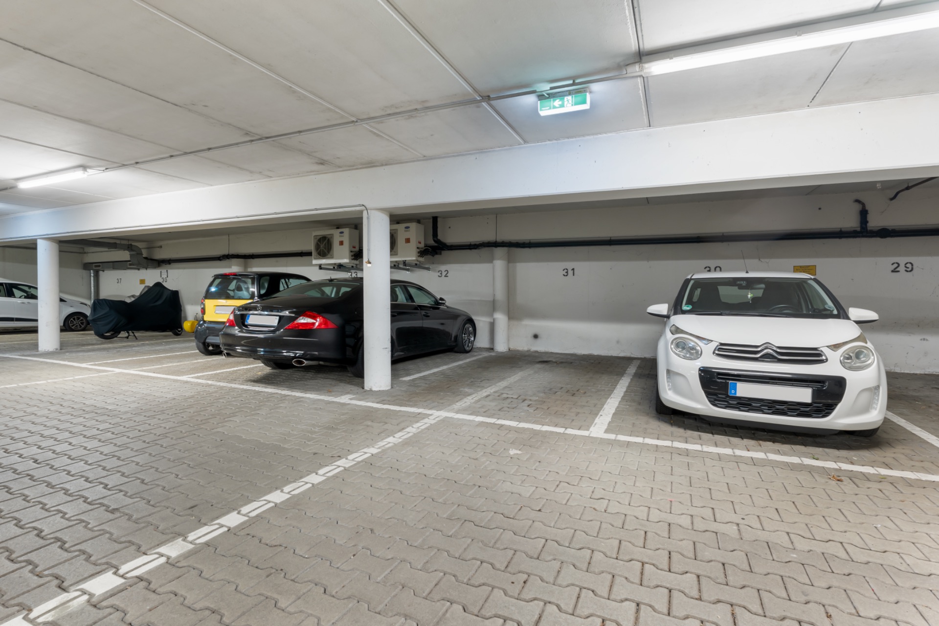 Tiefgaragenstellplätze mit mehreren parkenden Autos und markierten Parkbuchten.