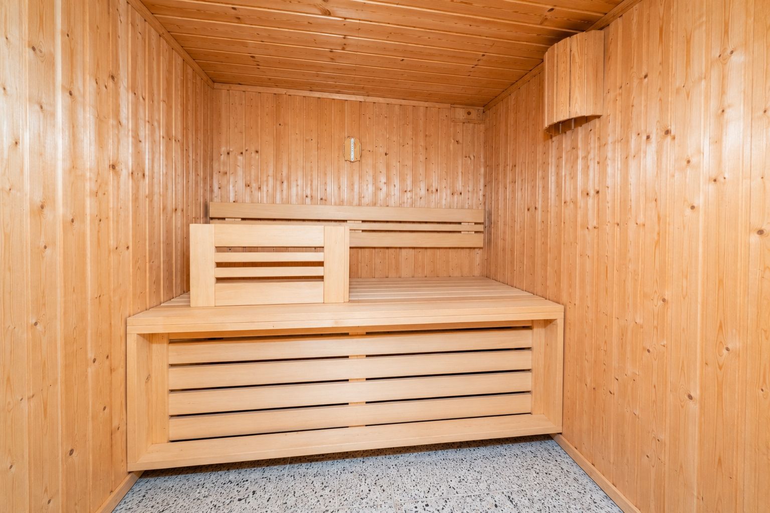 Holzsauna mit Bank und Holzverkleidung an Wänden und Decke.