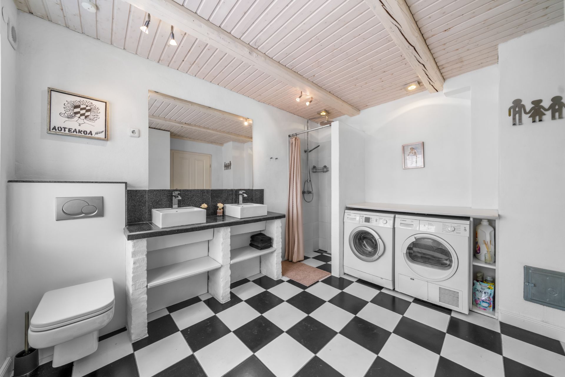 Modernes Badezimmer mit Dusche, Waschmaschine, Trockner und schwarz-weiß kariertem Boden.