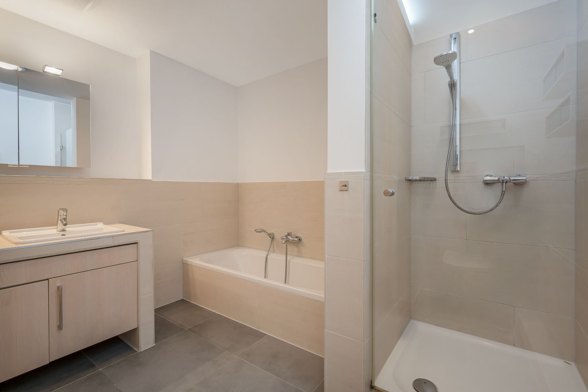 Modernes Badezimmer mit Dusche, Badewanne und Waschbecken mit Spiegel.
