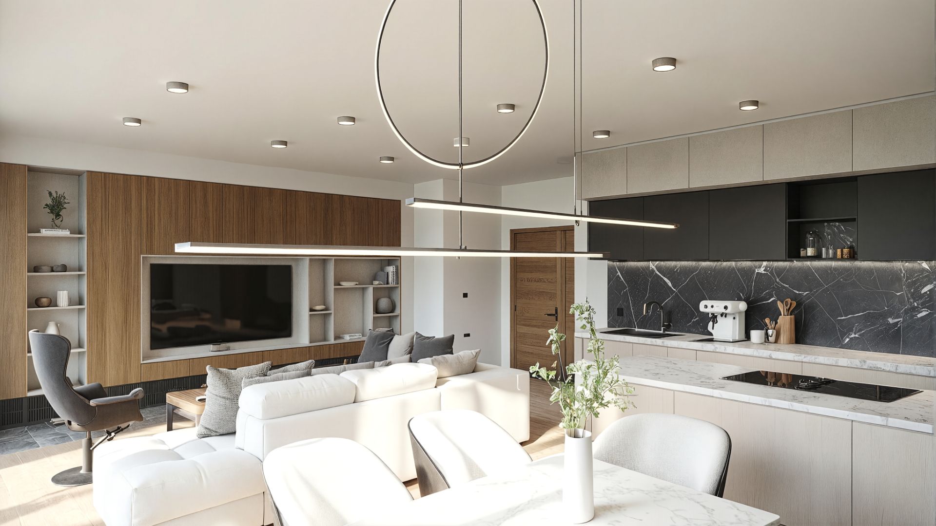 Modernes Wohnzimmer mit weißem Sofa, offenem Küchenbereich und großem Fernseher an der Wand.