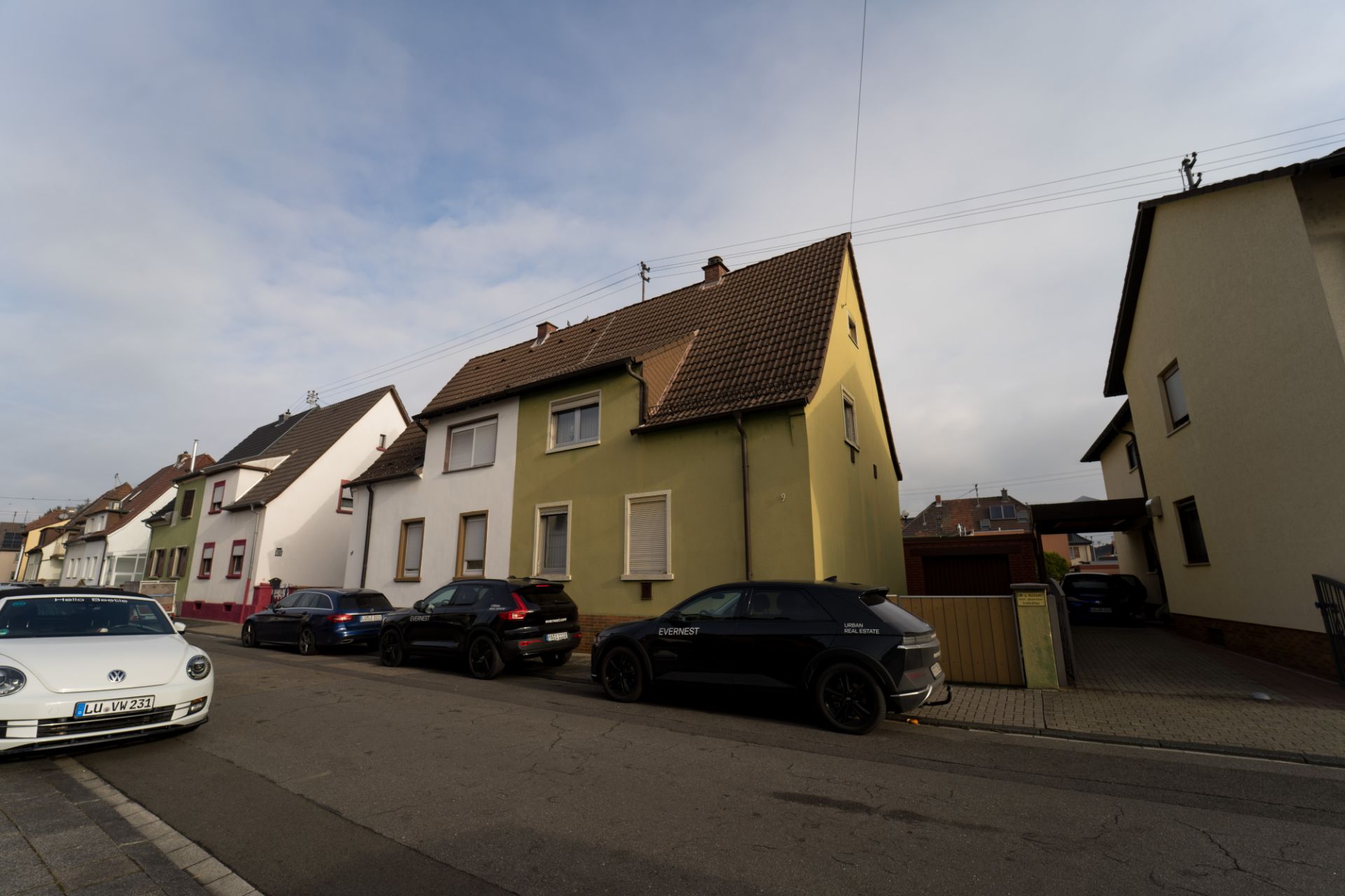 Reihen von Wohnhäusern mit mehreren Autos, die an der Straße parken.