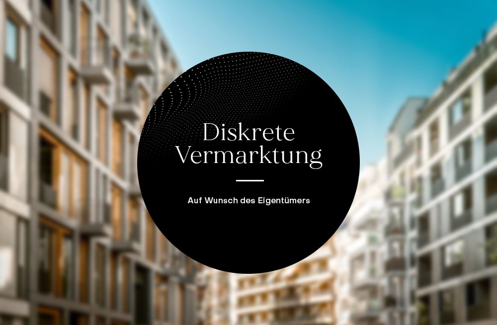 Unscharfe Ansicht mehrerer moderner Wohngebäude, schwarzer Kreis mit Text im Vordergrund.