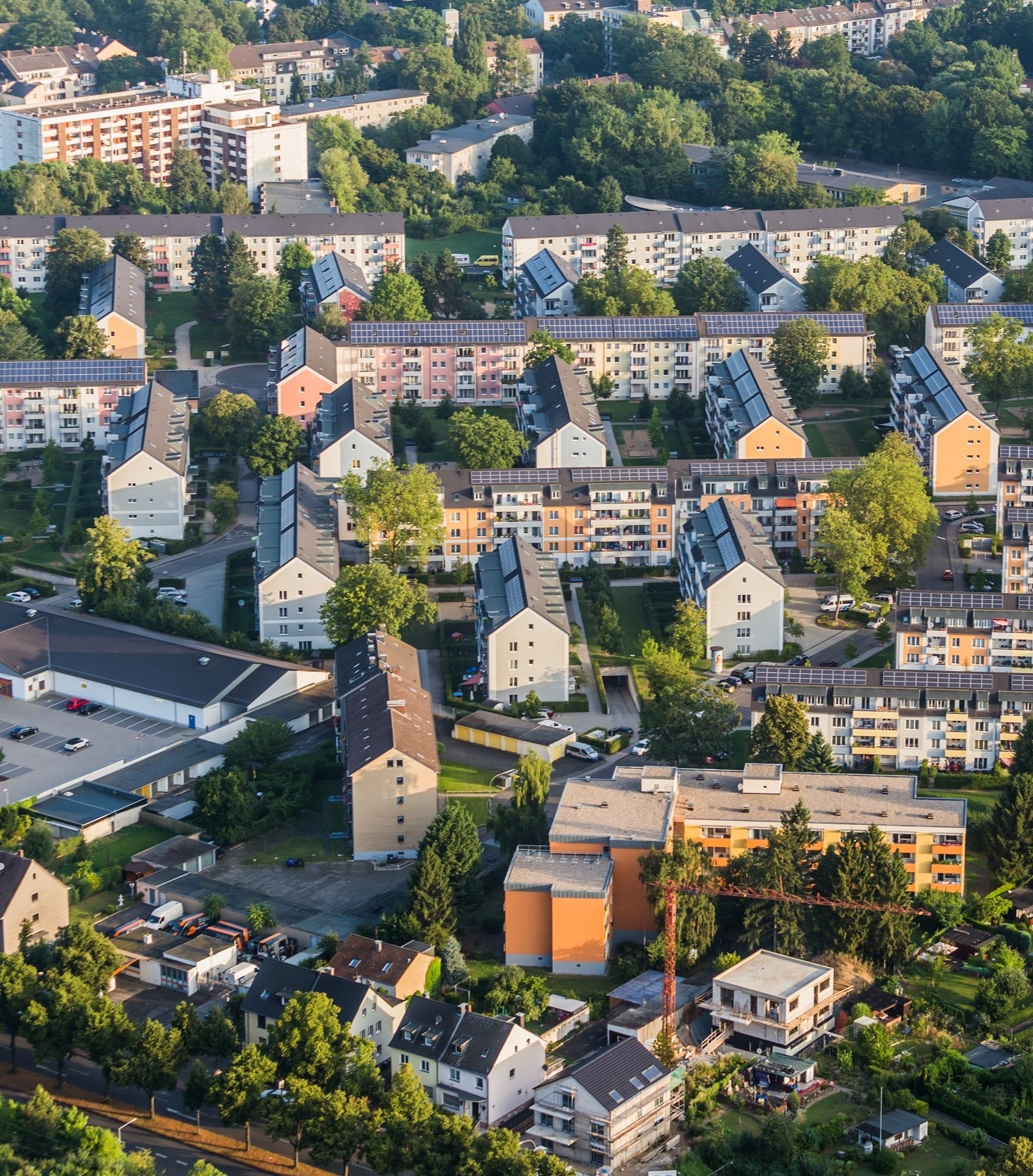 Luftaufnahme von Wohnhäusern mit Begrünung und Straßen dazwischen.