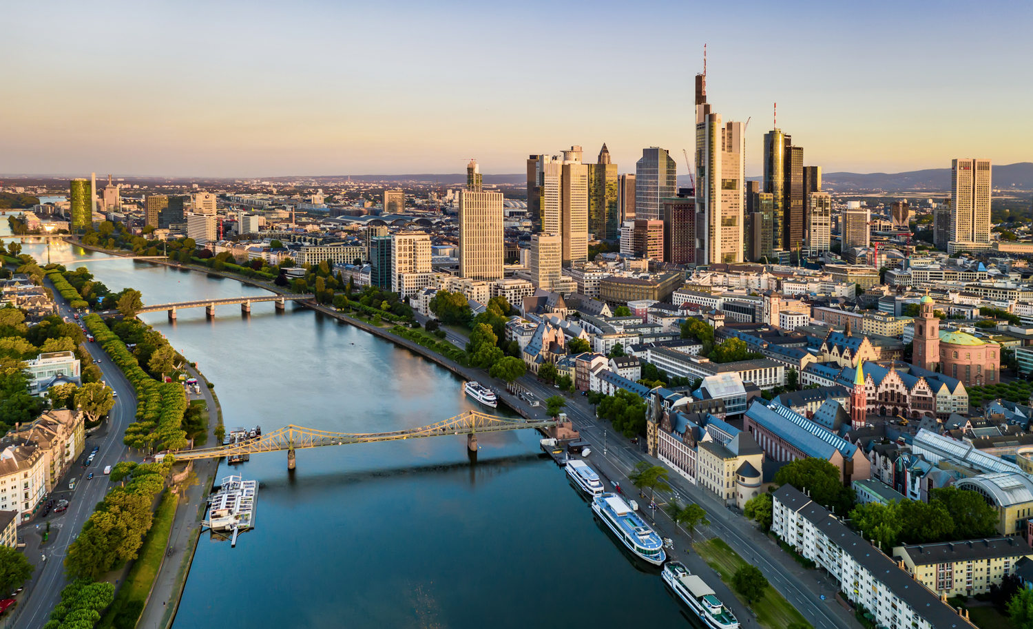 Luftaufnahme einer Stadt mit Fluss, Brücken, Hochhäusern und Wohngebäuden.