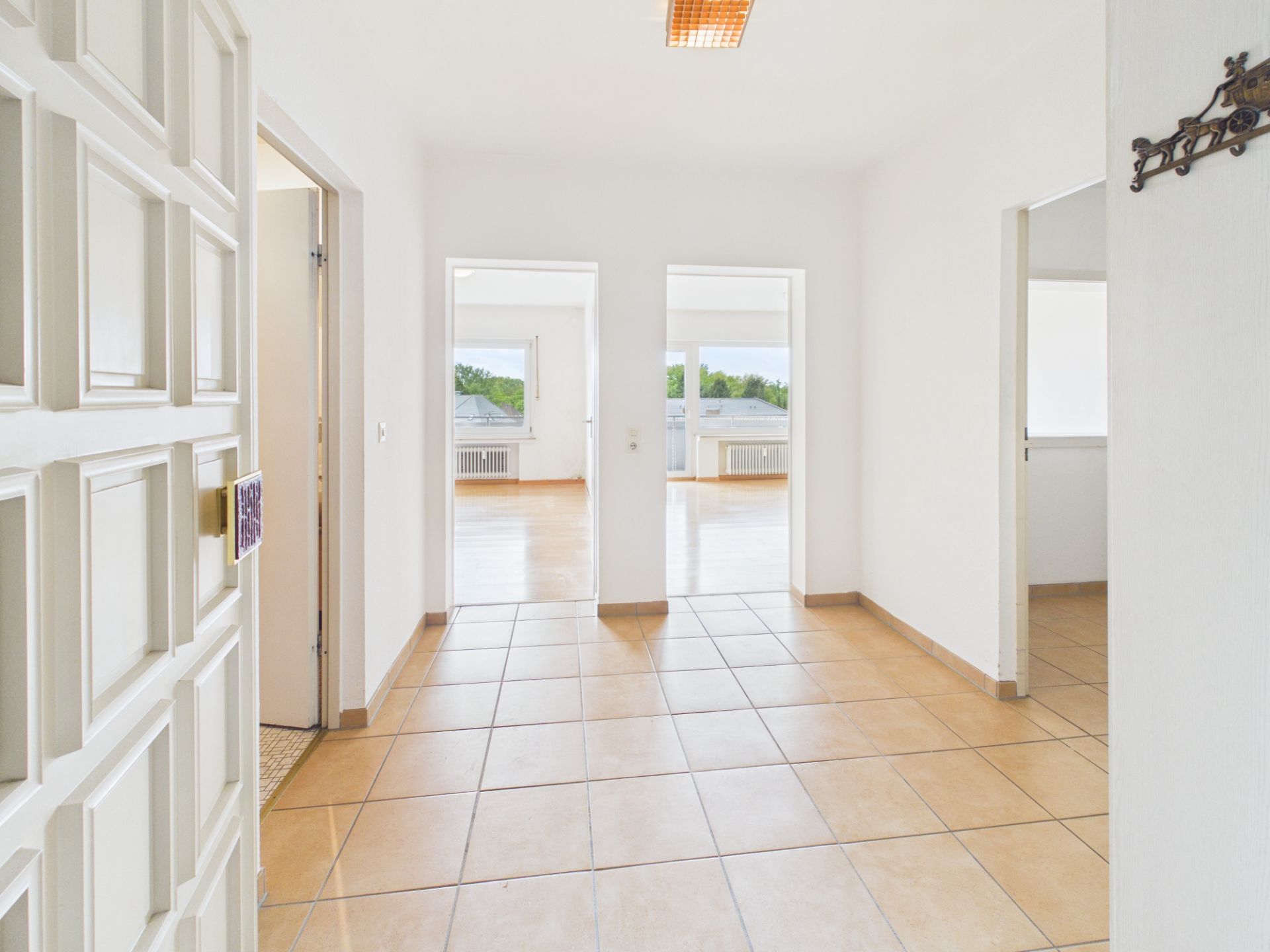 Heller Flur mit Fliesenboden und mehreren Türen zu weiteren Zimmern in einer Wohnung.
