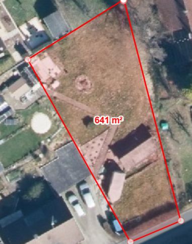 Luftbild eines Grundstücks mit rotem Rand, 641 m² groß, Rasenfläche und Gebäuden sichtbar.