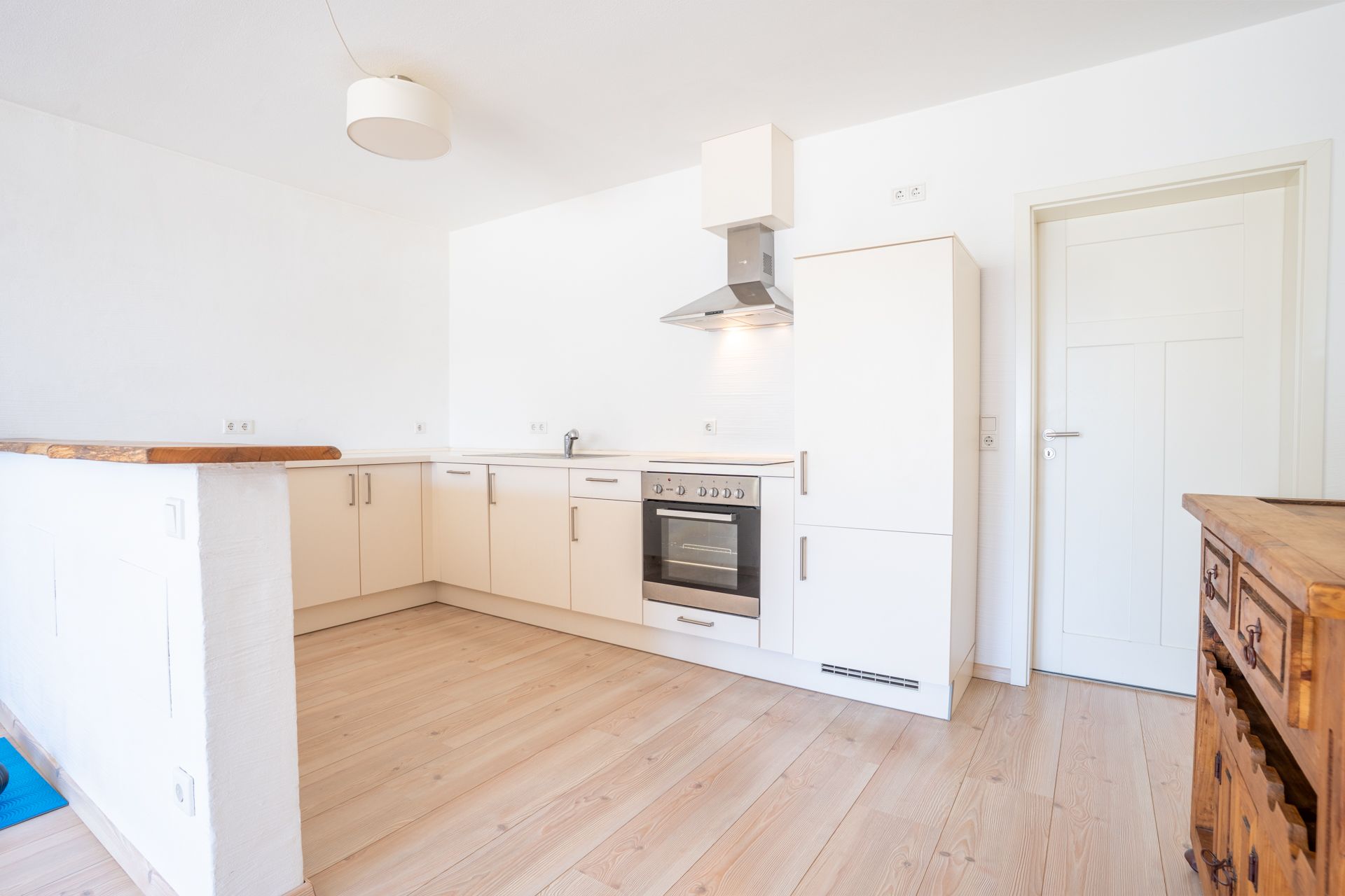 Helle, moderne Einbauküche mit Holzfußboden und weißen Schränken.