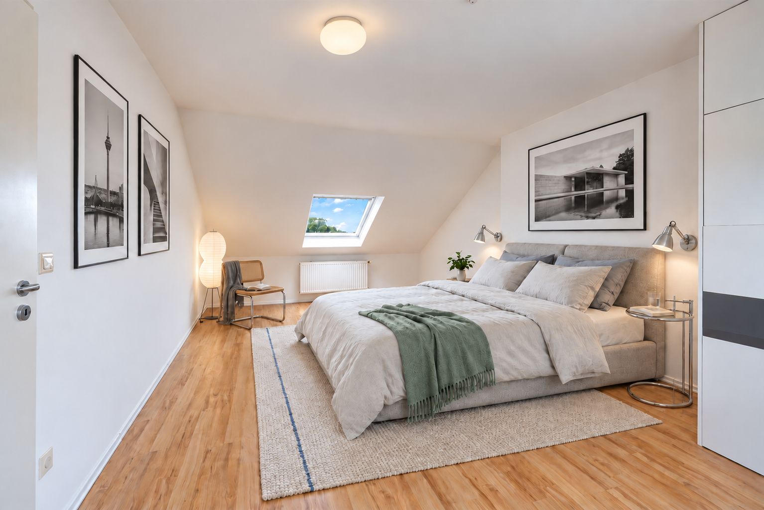 Modernes Schlafzimmer mit Doppelbett, Teppich, Bildern an den Wänden und Dachfenster.