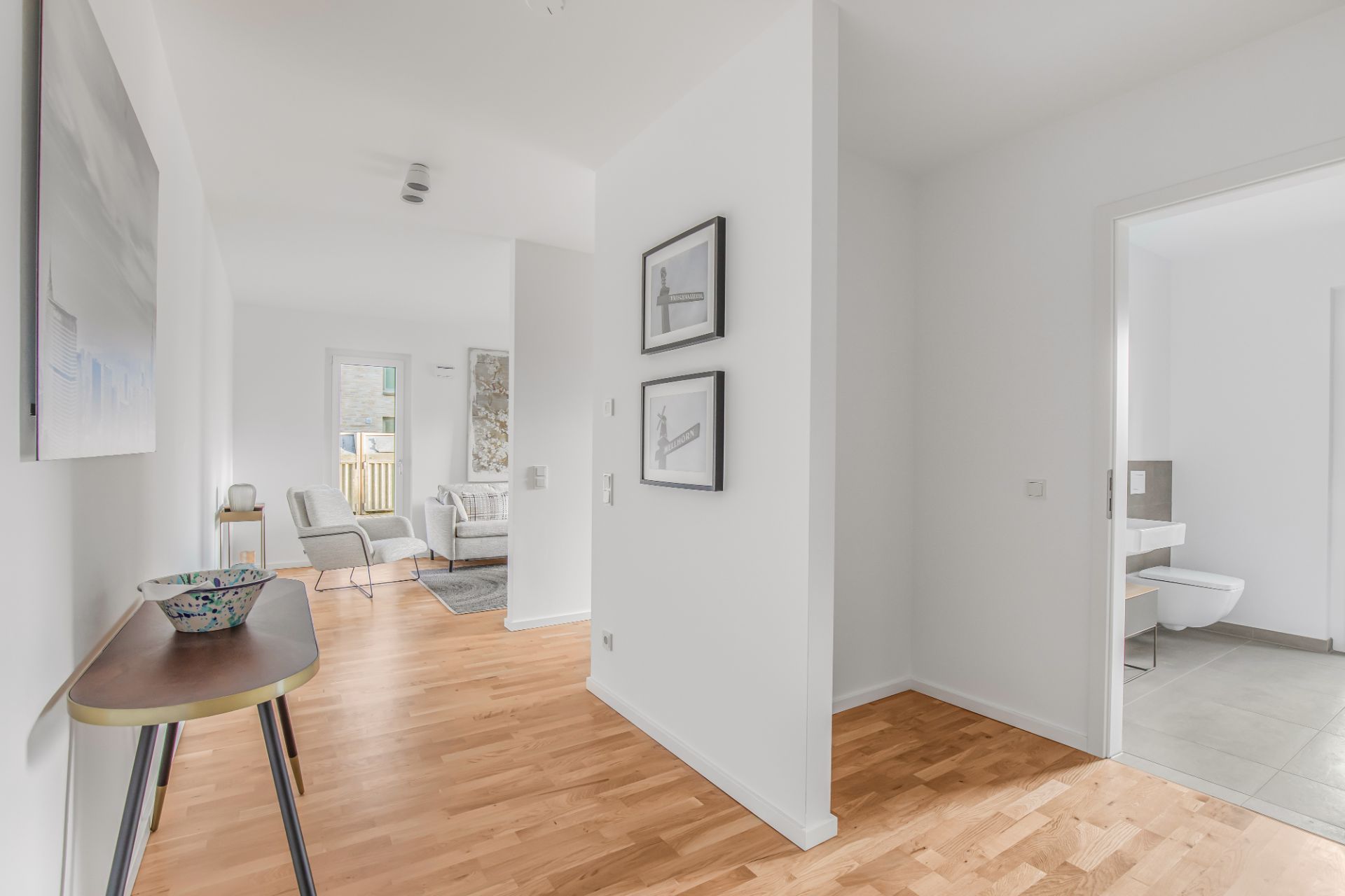 Heller Flur mit Holzboden, Zugang zum Wohnzimmer und Badezimmer, moderne Einrichtung.