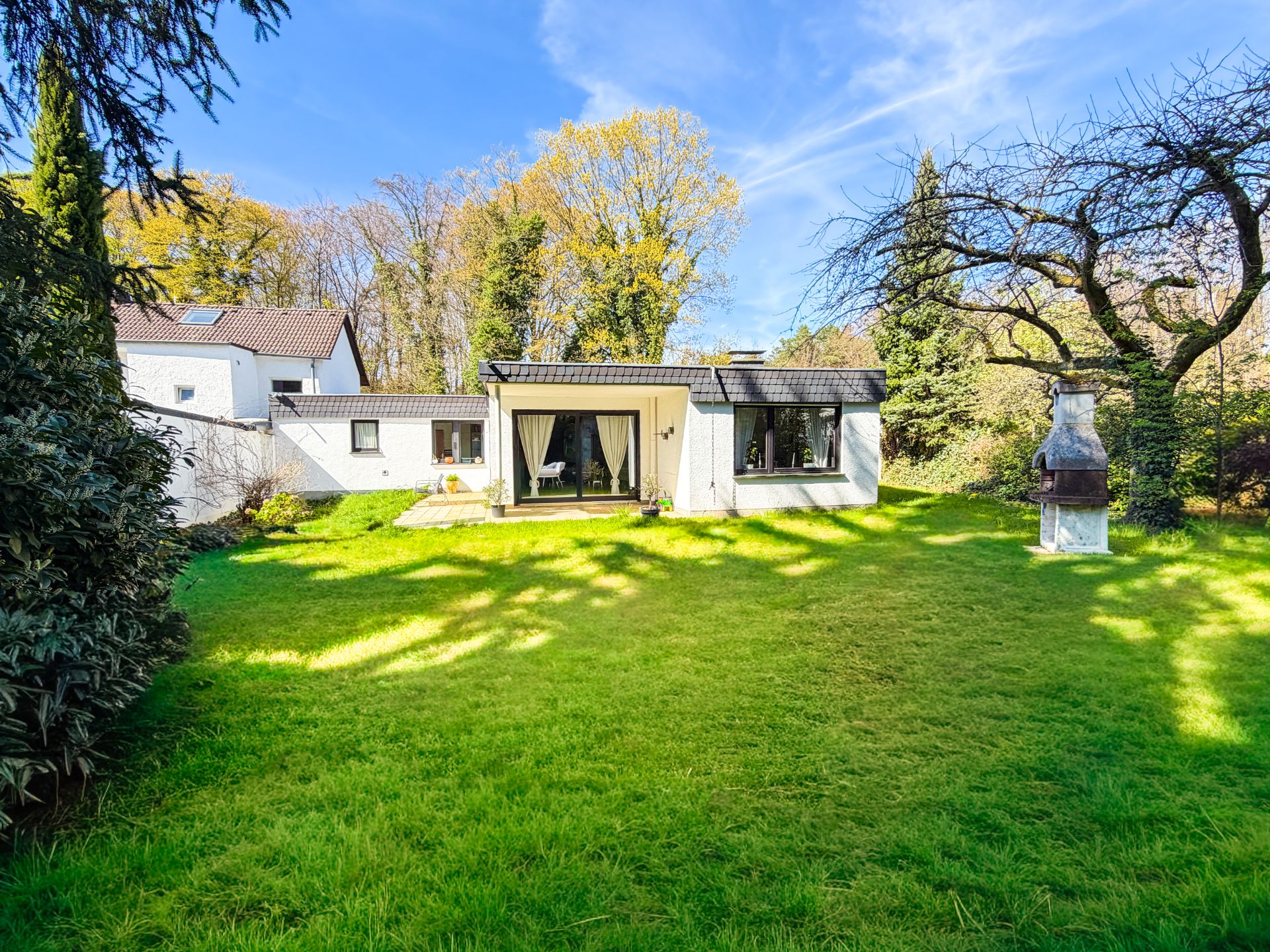 Einfamilienhaus mit großem Garten, Terrasse und gemauertem Grill im Grünen.