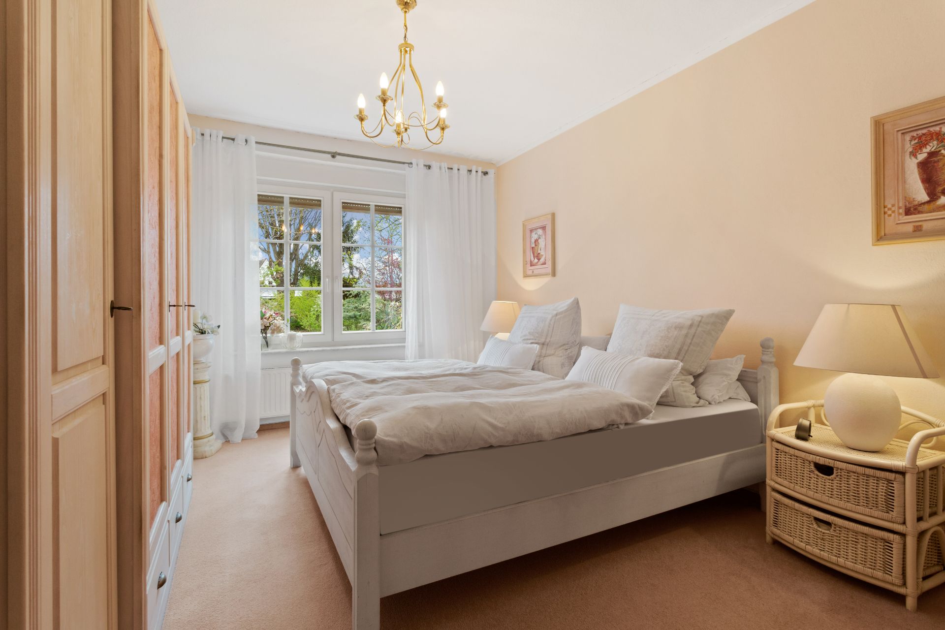 Helles Schlafzimmer mit Doppelbett, Nachttischen, großen Fenstern und Schrank.