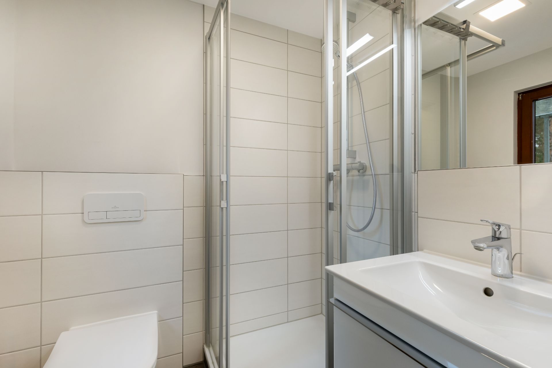 Modernes Badezimmer mit Dusche, Waschbecken und Toilette.