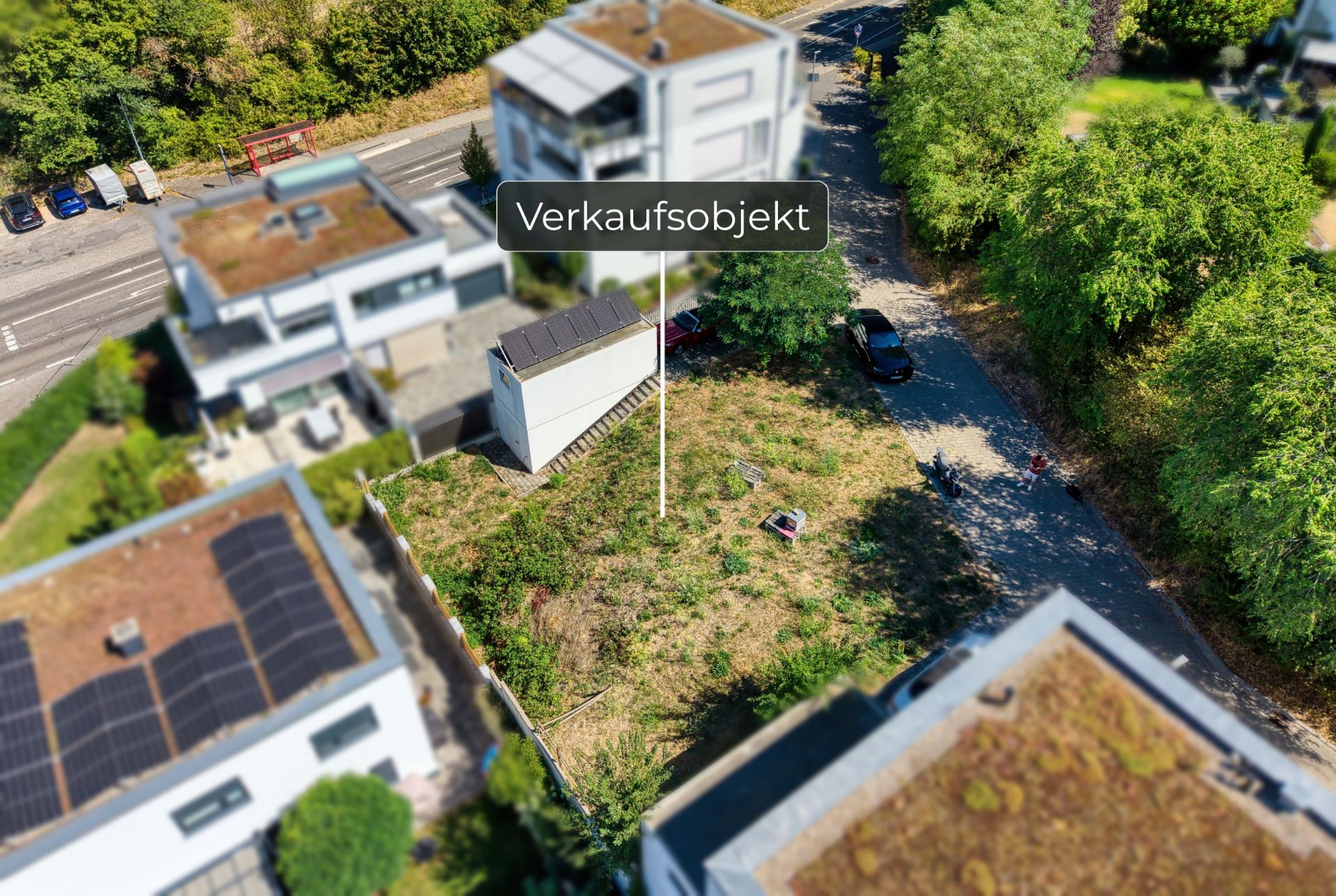 Luftaufnahme eines Grundstücks mit Rasen, umgeben von modernen Wohnhäusern.