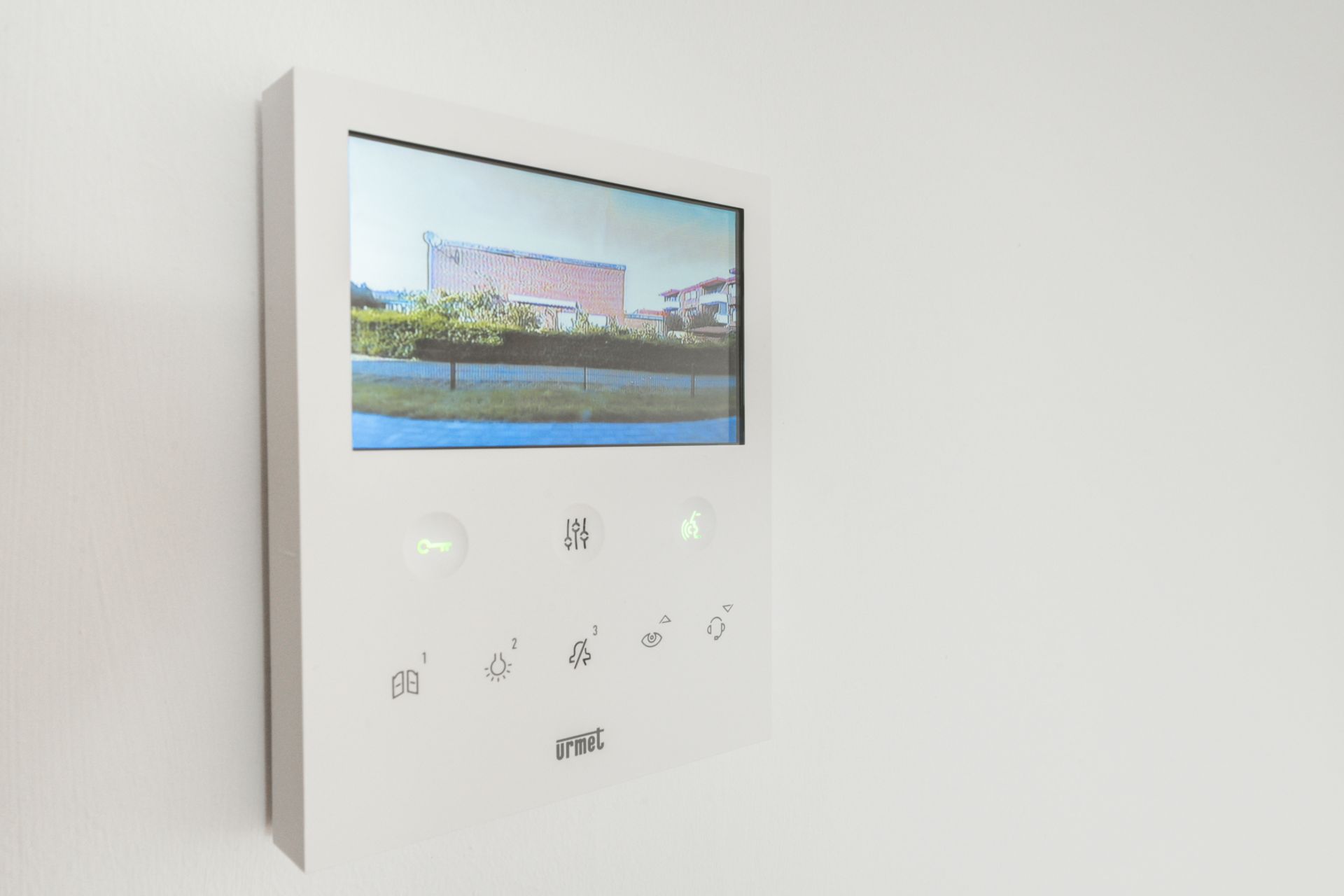 Wandmontierter Monitor mit Videobild einer Außenansicht eines Hauses.