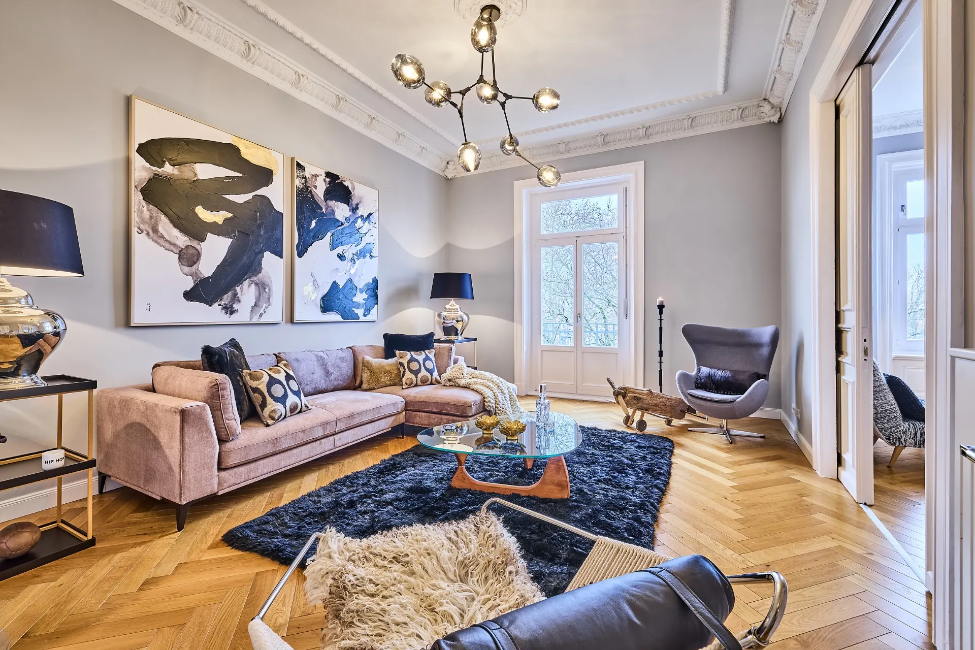 Modernes Wohnzimmer mit Sofa, Couchtisch, Teppich, Sessel und großem Fenster.