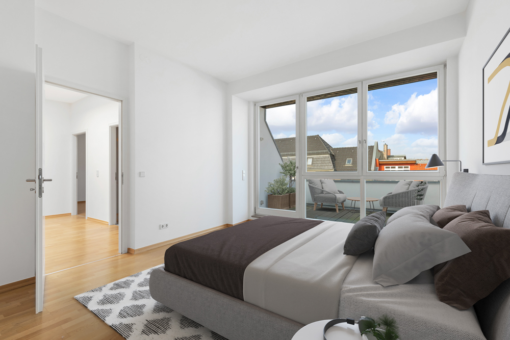 Modernes Schlafzimmer mit großem Bett, Teppich und Zugang zu einem Balkon mit Sitzmöbeln.