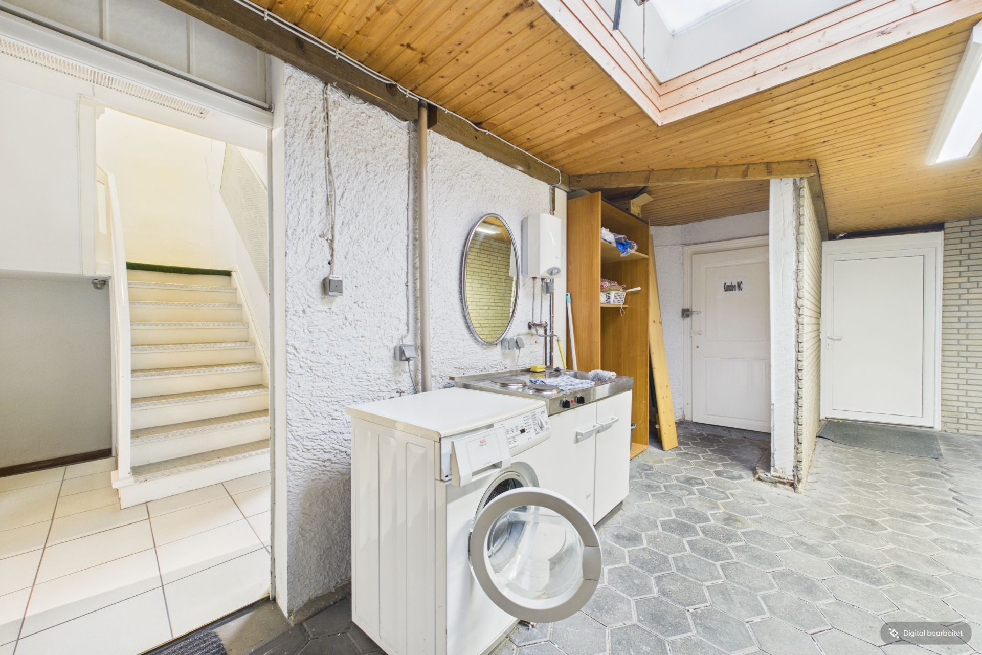 Waschraum mit Waschmaschine, rundem Spiegel und Holzboden an der Decke.