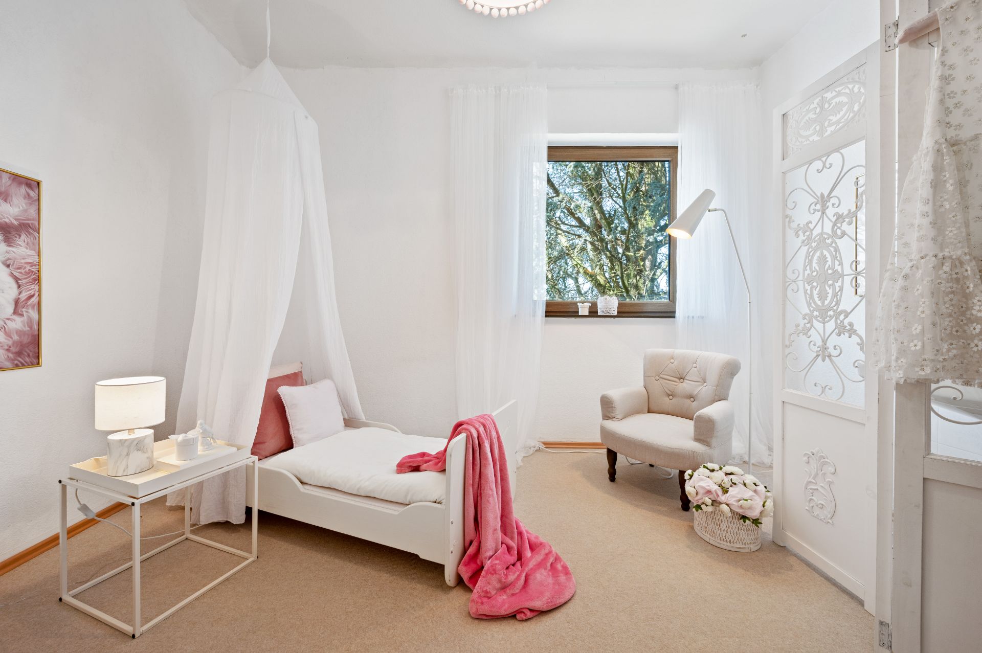 Helles Schlafzimmer mit Einzelbett, Sessel, Nachttisch und Fenster mit Blick ins Grüne.