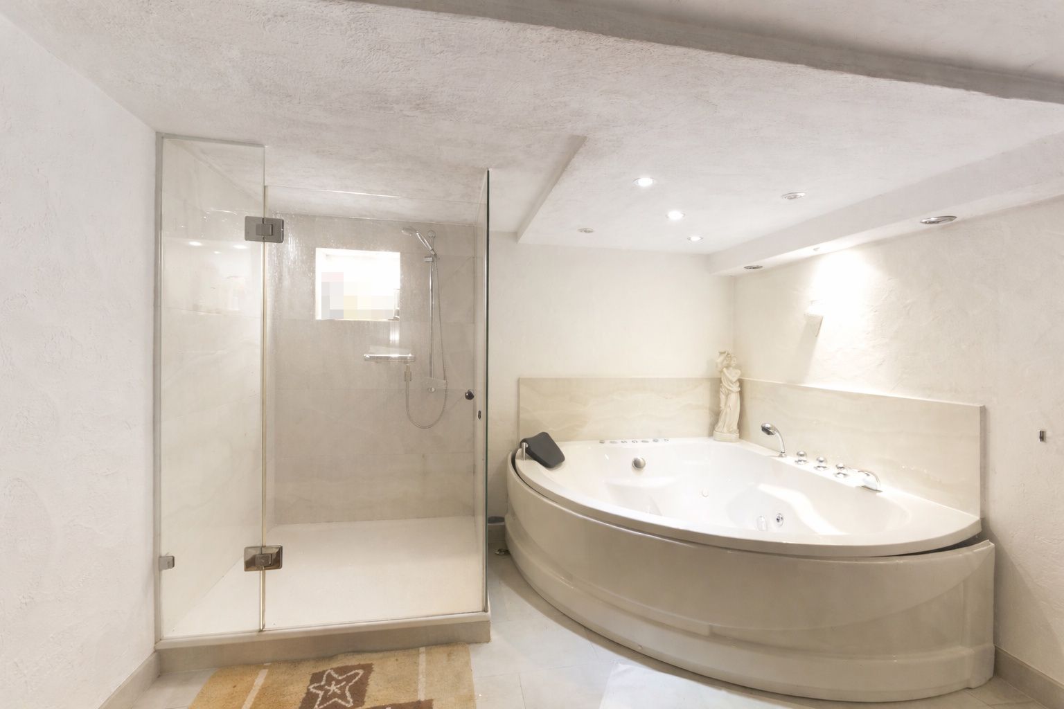Modernes Badezimmer mit großer Dusche und runder Badewanne.