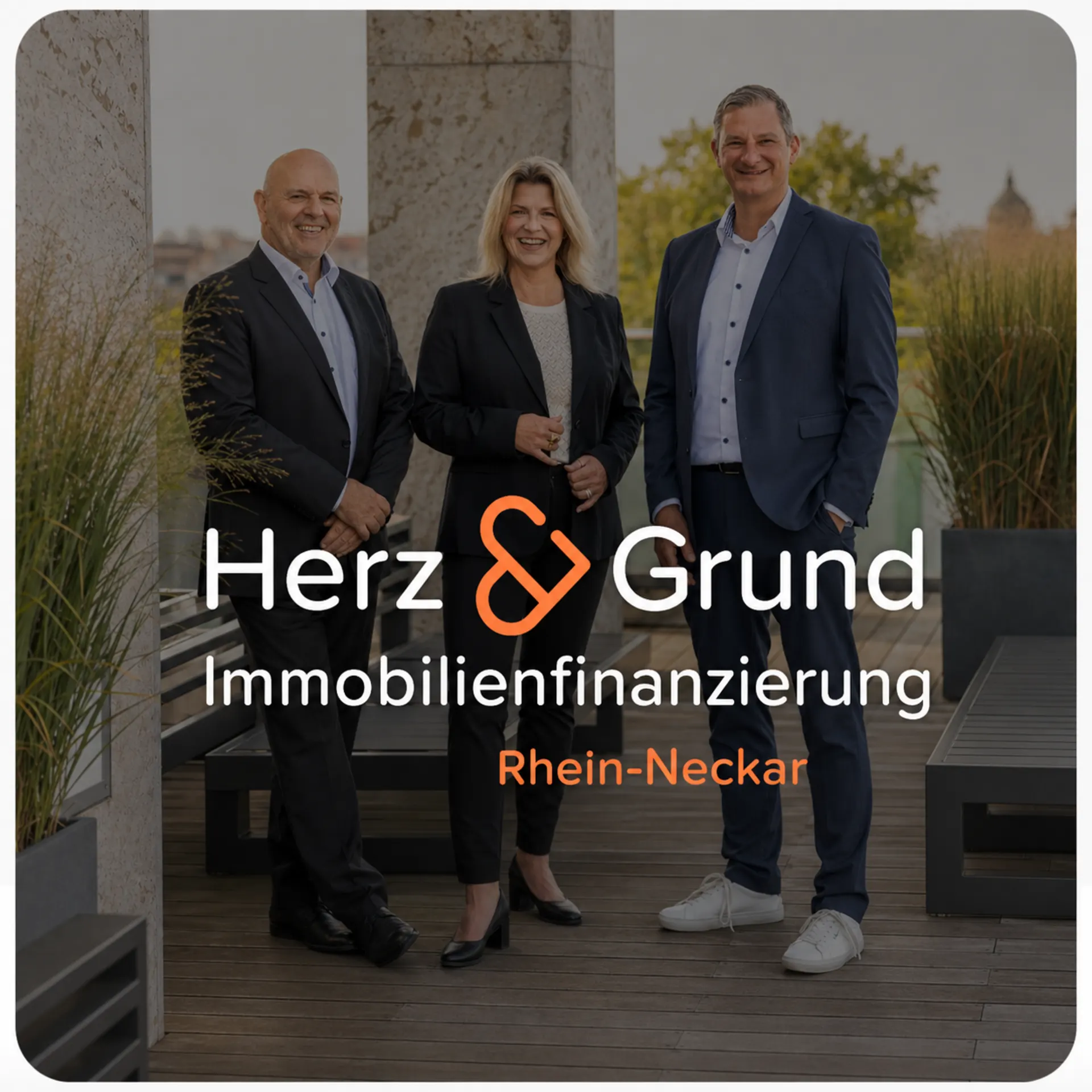 Drei Personen in Anzügen stehen auf einer Terrasse neben Pflanzen.