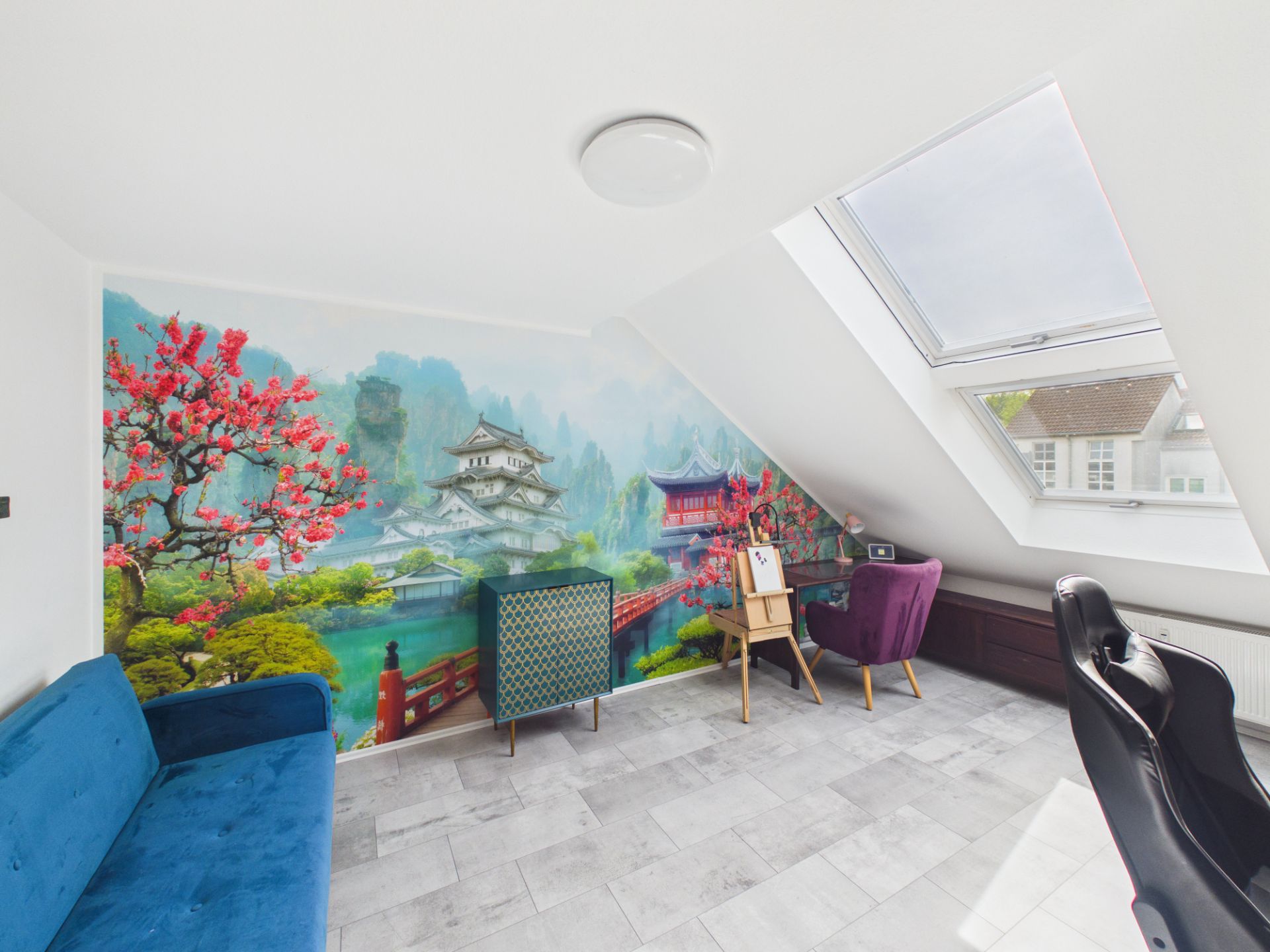 Heller Raum mit Sofa, Stuhl, Schreibtisch und Wandbild mit asiatischem Gartenmotiv.