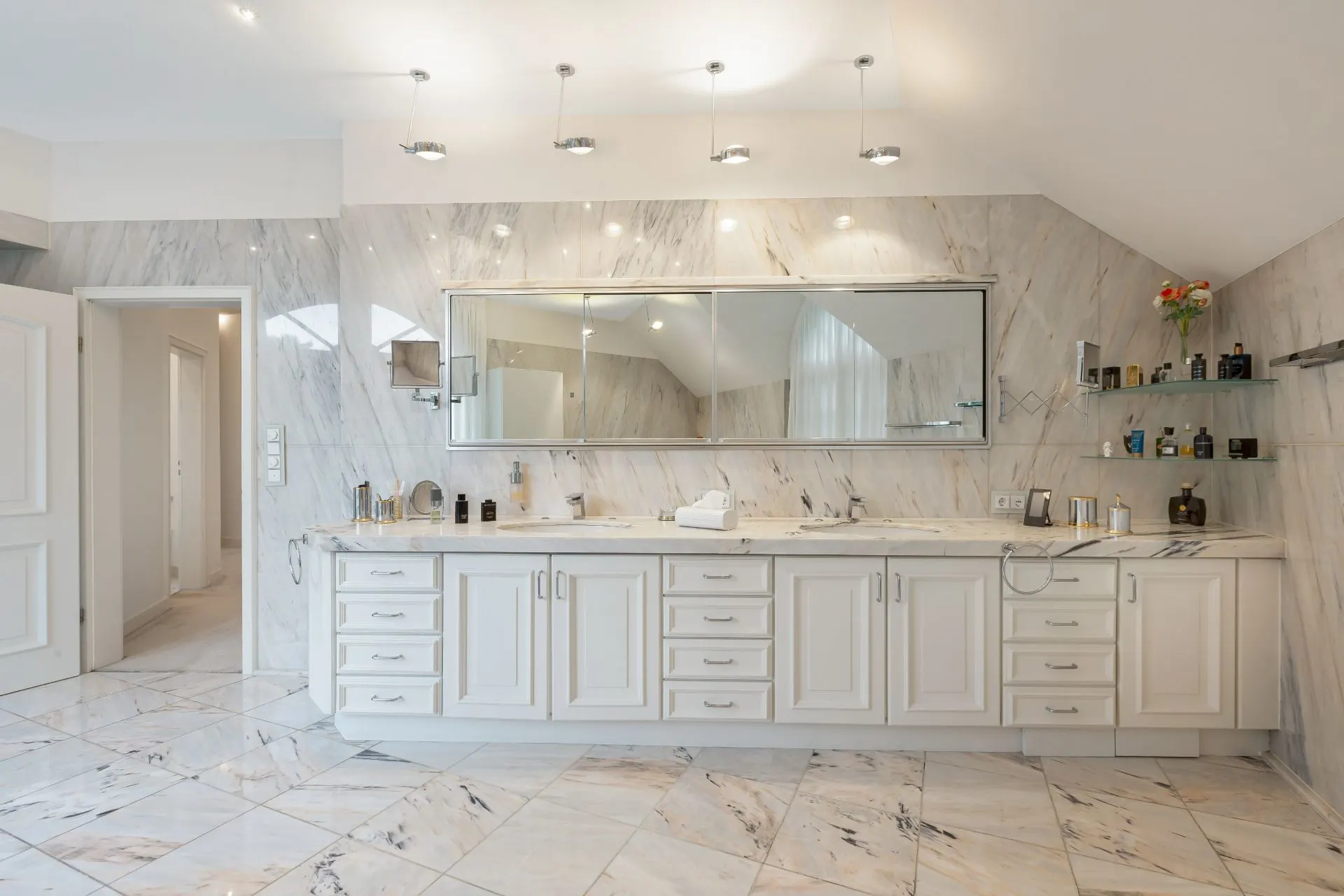 Modernes Badezimmer mit weißem Marmorboden, großem Spiegel und Doppelwaschbecken.