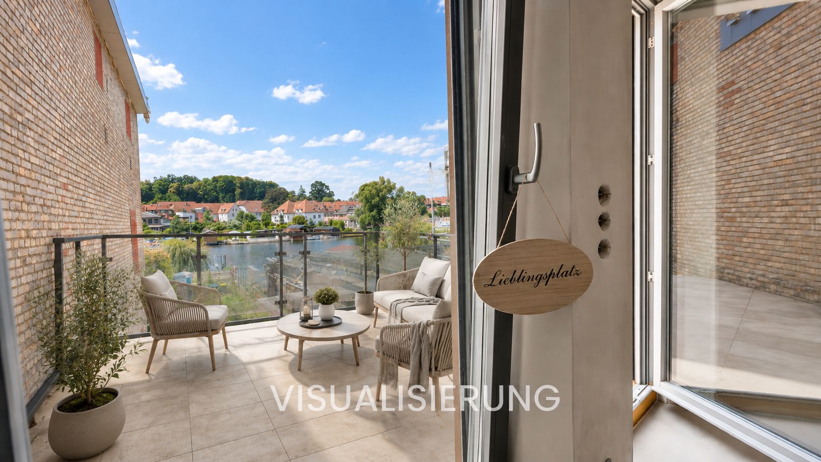 Balkon mit zwei Stühlen, Tisch, Pflanzen und Ausblick auf Wasser und Häuser.