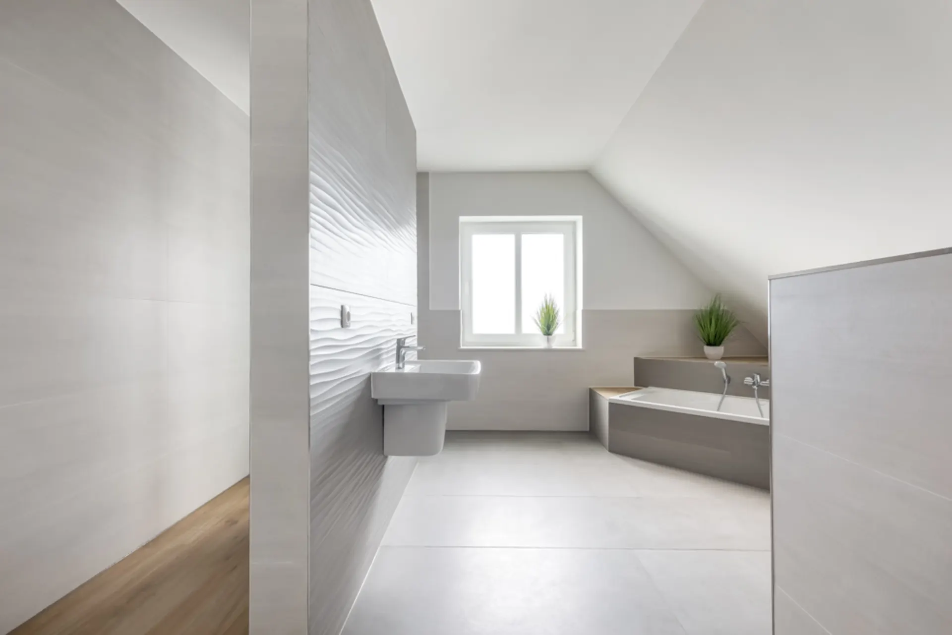 Modernes, helles Badezimmer mit Badewanne, Waschbecken und zwei Pflanzen am Fenster.