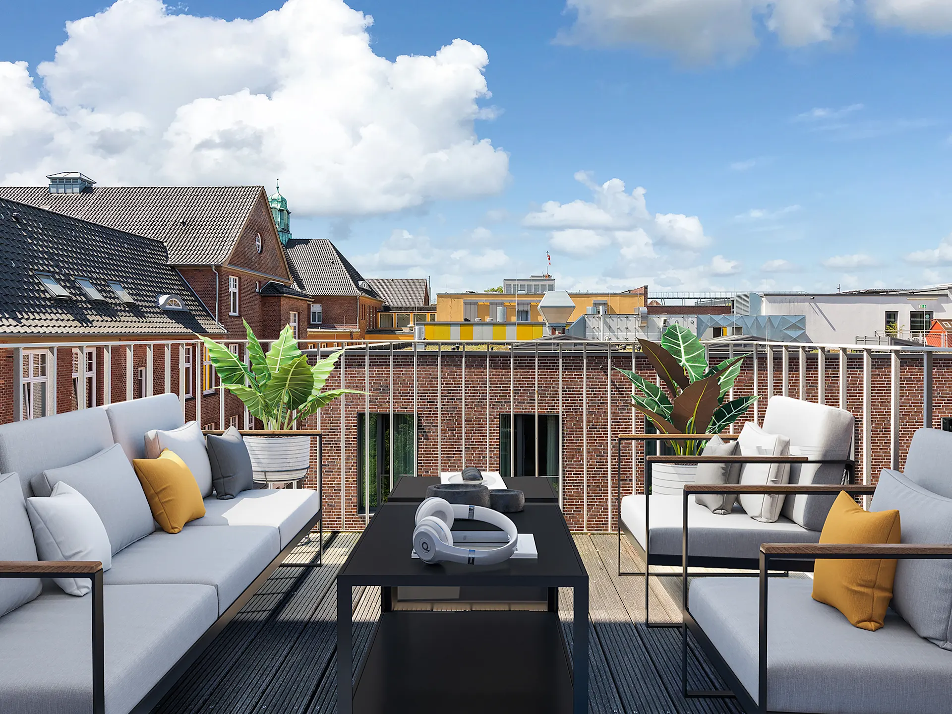 Möblierte Dachterrasse mit Sofas, Tisch, Pflanzen und Blick auf Nachbarhäuser unter blauem Himmel.